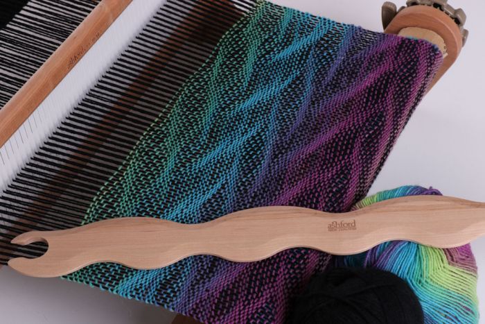 Ashford Wavy Shuttle with rigid heddle loom black warp and colorful wavy weft pattern