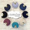 Cumulus yarn by Fyberspates, 8 balls in a circle surrounding the Cumulus logo