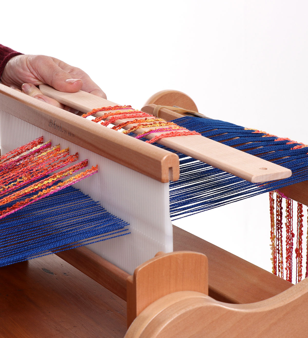 Ashford pickup stick shown in weaving on an Ashford rigid heddle loom with colorful warp